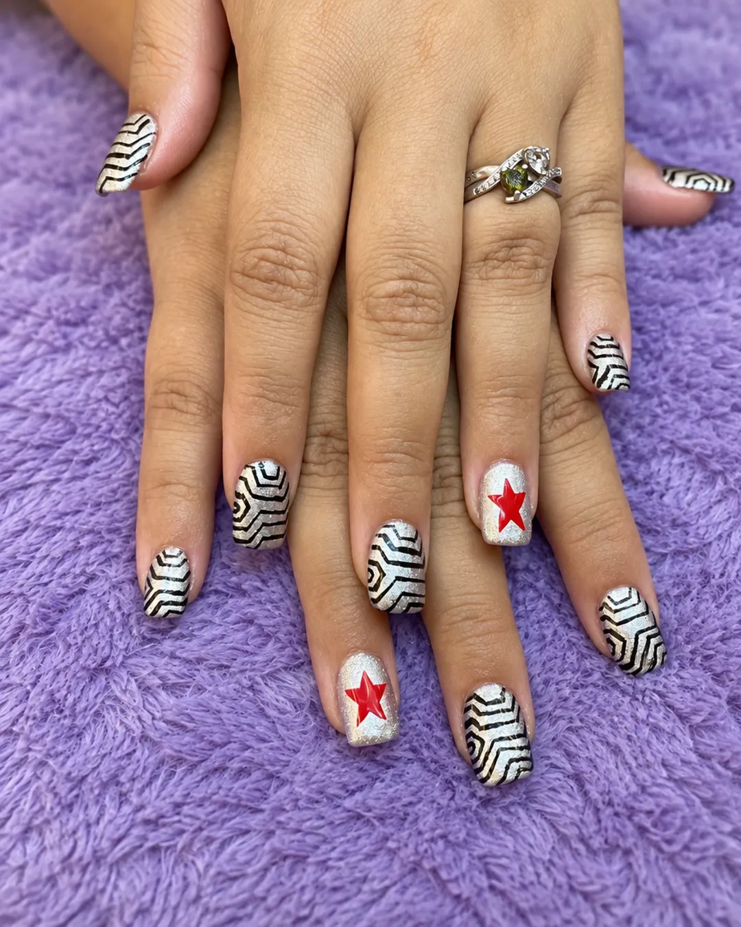 Short black-and-white zebra nail art with red star accents