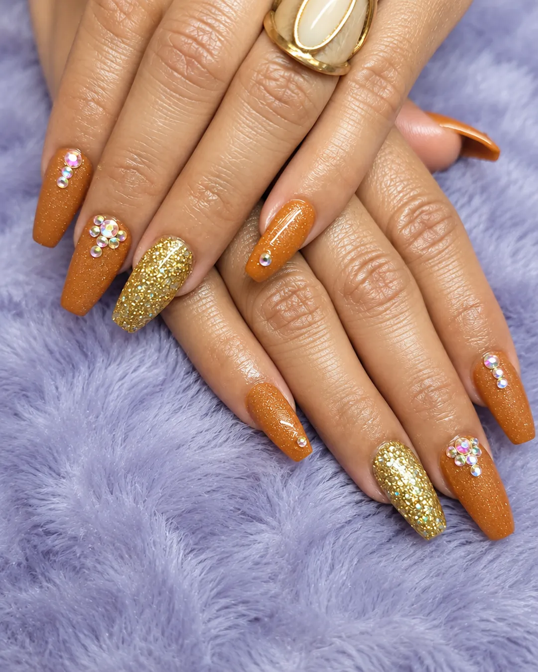 Burnt orange coffin nails with gold glitter and rhinestones