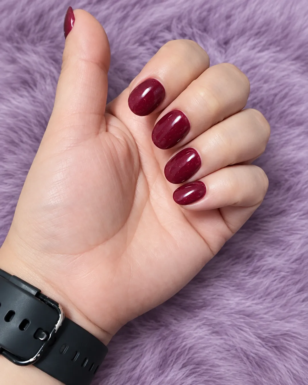 Short rounded nails in deep burgundy polish